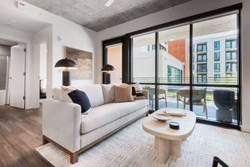 Austin apartment for rent - A modern living room with a white couch and a large window.