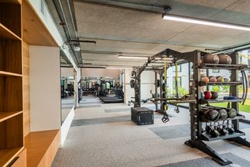 Austin apartment for rent - A gym with a variety of equipment including weights and a bench press.