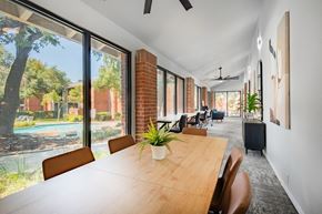 Austin apartment for rent - a large dining room with a wooden table and chairs and large windows