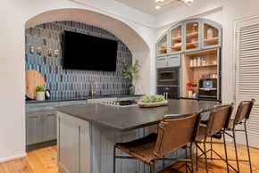 San Antonio apartment for rent - a kitchen with a large island with chairs and a tv at The Can Plant Residences at Pearl, Texas, 78215