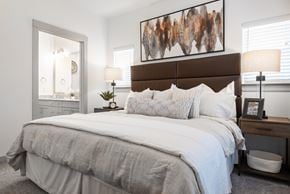 New Braunfels townhouse for rent - A bedroom with a large bed and a painting above it.