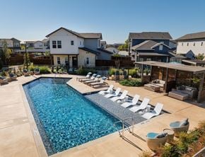 Fort Worth townhouse for rent - A swimming pool surrounded by lounge chairs and a wooden pergola.