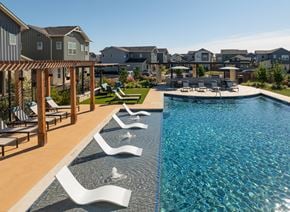 New Braunfels townhouse for rent - A pool with a wooden deck and white chairs.
