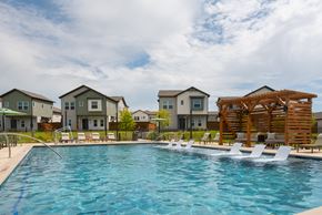 Fort Worth townhouse for rent - A swimming pool in front of a row of houses.