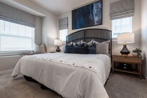 Schertz townhouse for rent - A bedroom with a large bed and a painting on the wall.
