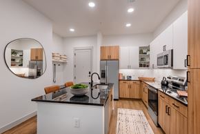 Charlotte apartment for rent - A modern kitchen with wooden cabinets and a black countertop.