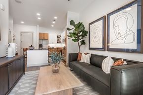 Charlotte apartment for rent - A living room with a couch, coffee table, and two framed artworks on the wall.