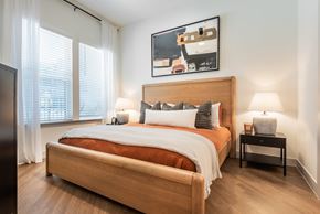 Charlotte apartment for rent - A bedroom with a large bed and a painting above it.