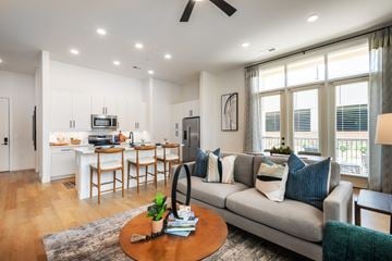Charlotte apartment for rent - A modern living room with a grey couch and a wooden coffee table.