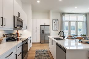 Charlotte apartment for rent - A modern kitchen with white cabinets and a central island.