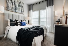 Fort Worth townhouse for rent - A bedroom with a large bed and a painting on the wall.
