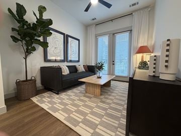 Charlotte apartment for rent - A living room with a black couch and a wooden coffee table.