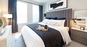 Lewisville apartment for rent - A bedroom with a large bed and a painting above it.