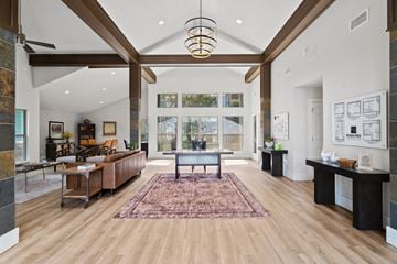 Austin apartment for rent - A large, open living room with a rug on the floor and a long table with chairs.