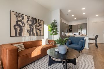 Charlotte apartment for rent - A living room with a brown couch and a large abstract painting on the wall.