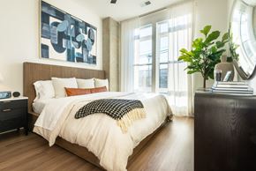 Charlotte apartment for rent - A bedroom with a large bed and a painting on the wall.