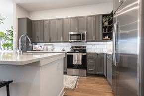 Charlotte apartment for rent - A modern kitchen with a stainless steel refrigerator and a white countertop.
