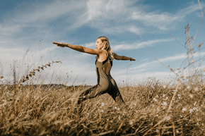 Littleton apartment for rent - A woman in a black dress is standing in a field with her arms outstretched.