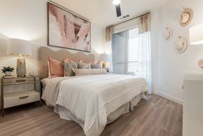 Denver apartment for rent - A bedroom with a large bed and a painting above it.
