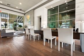 Kyle apartment for rent - a dining area with a long wooden table and white chairs