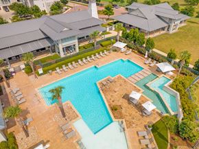 Kyle apartment for rent - an aerial view of a resort style pool with lounge chairs and umbrellas
