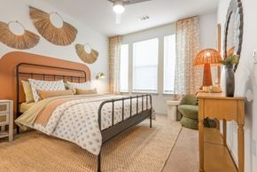 Littleton apartment for rent - A bedroom with a bed, a chair, and a table with a lamp on it.