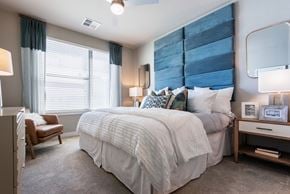 Peoria apartment for rent - A bedroom with a large bed and a chair.