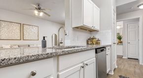 Selma apartment for rent - a kitchen with white cabinets and granite countertops