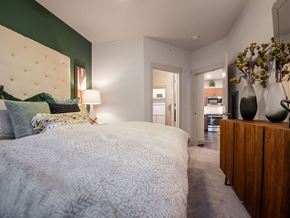 Littleton apartment for rent - a bedroom with a white bed and a green wall