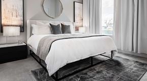 San Antonio apartment for rent - A bedroom with a large bed and a round mirror on the wall.