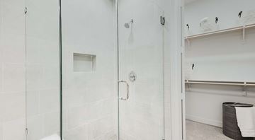 San Antonio apartment for rent - A white bathroom with a glass shower door and a towel rack.