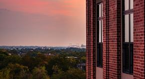 San Antonio apartment for rent - A red brick building with a view of the city in the background.