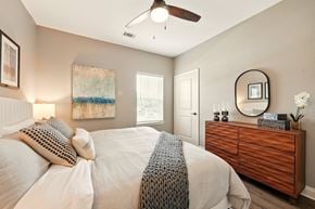 Lake Charles apartment for rent - A bedroom with a bed, dresser, and a ceiling fan. at Beau Chene Lake Charles Apartments, Lake Charles, LA, 70605