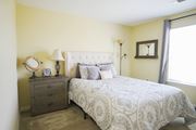 Big Spring townhouse for rent - A bedroom with a queen bed, nightstand, and lamp.