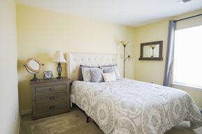 Big Spring townhouse for rent - A bedroom with a queen bed, nightstand, and lamp.