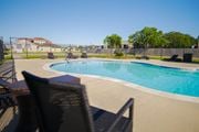 Bay City townhouse for rent - a swimming pool with chairs around it in front of a fence