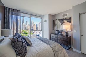 Chicago apartment for rent - 1 bedroom with queen sized bed, dresser, and night stand with lamp