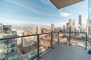 Chicago apartment for rent - A balcony overlooks a cityscape with tall buildings.