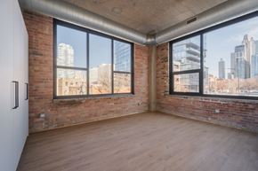 Chicago apartment for rent - A room with a brick wall and wooden floor.
