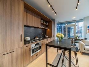 Chicago apartment for rent - a kitchen with wooden cabinets and a table with stools