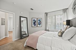 Orlando apartment for rent - A bedroom with a large bed and a mirror on the wall.