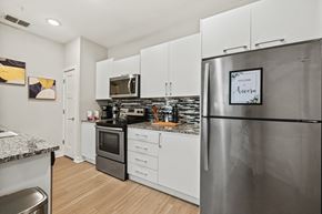 Orlando apartment for rent - A modern kitchen with a stainless steel refrigerator and white cabinets.