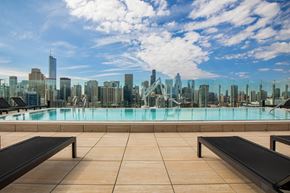 Chicago apartment for rent - A pool with benches overlooking a city skyline.