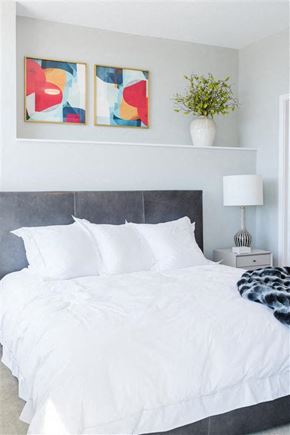 Nashville apartment for rent - a bedroom with a white bed and two paintings on the wall
