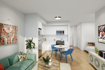 Chicago apartment for rent - A living room with a green couch, a coffee table, and a dining table with chairs.