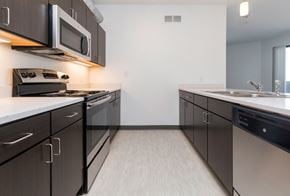 Des Moines apartment for rent - Modern open-concept kitchen and living area with stainless steel appliances.