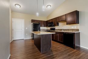 Sioux Falls apartment for rent - A kitchen with dark wood cabinets and a white countertop.