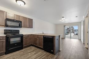 Sioux Falls apartment for rent - A kitchen with wooden cabinets and black appliances.