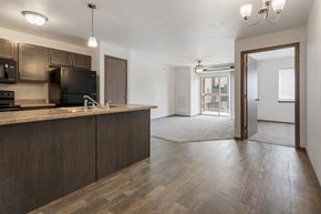 Sioux Falls townhouse for rent - A kitchen with dark wood cabinets and a black stove top oven.