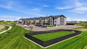 Sioux Falls apartment for rent - A large building with a black fence in front of it.